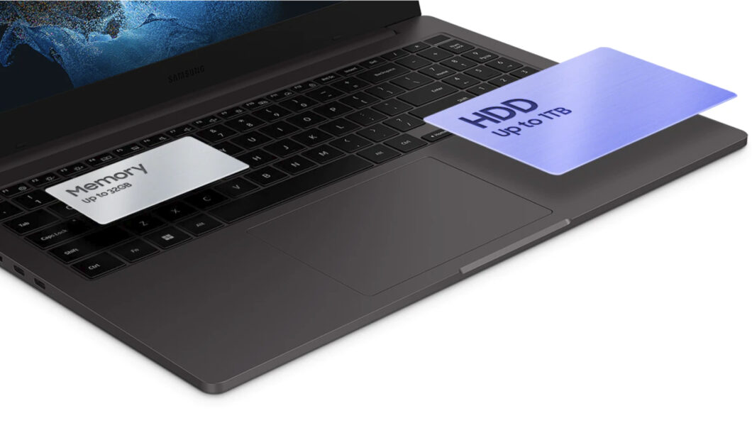 Notebook Samsung Galaxy Book 2 aberto sobre uma superfície branca, com cartões indicando memória de até 32GB e HDD de até 1TB sobre o teclado e o touchpad