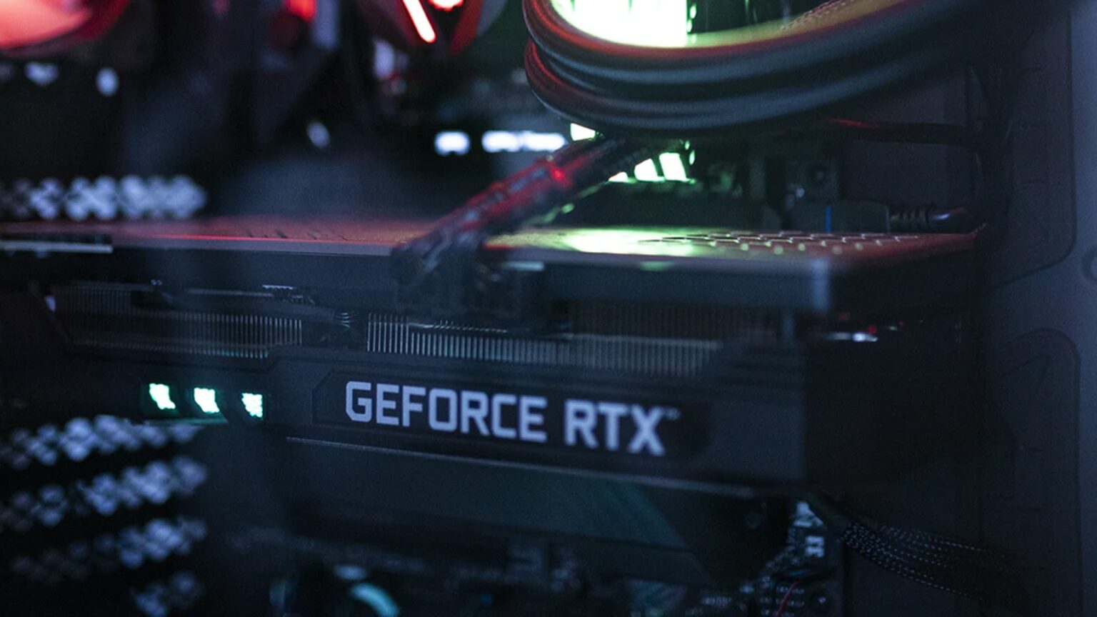 Placa de vídeo GeForce RTX instalada em um gabinete de PC gamer com iluminação vermelha e verde, com o logo GeForce RTX visível na lateral do cooler