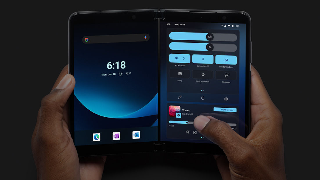 Dispositivo dobrável de duas telas, segurado por duas mãos, exibindo tela inicial com relógio e menu de configurações rápidas do Android