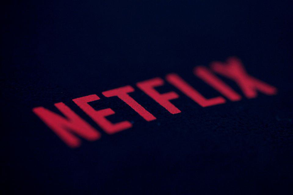 Logotipo da Netflix em letras vermelhas sobre fundo escuro, em close com foco inclinado