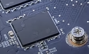 Close de uma placa de vídeo mostrando o chip de memória GDDR com a superfície visivelmente riscada e desgastada, com parte da pintura removida ao redor