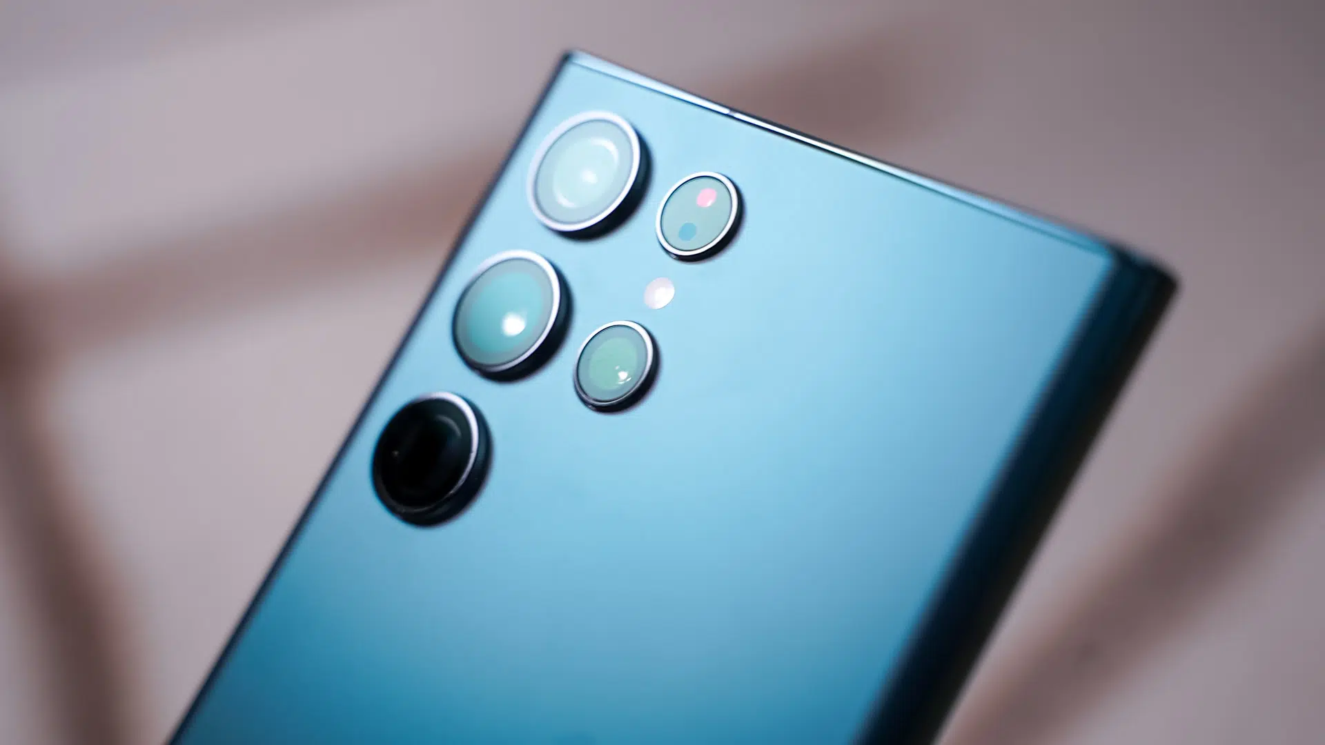 Traseira azul de smartphone Samsung Galaxy S23 Ultra em close, mostrando o módulo com quatro câmeras e o flash