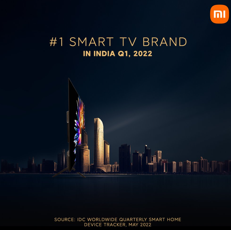 Peça promocional da Xiaomi com uma TV Smart de tela curva sobre um horizonte de prédios à noite, com o texto "#1 Smart TV Brand in India Q1, 2022