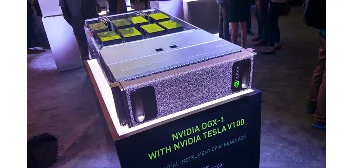 Servidor NVIDIA DGX-1 com GPUs Tesla V100 exibido sobre pedestal em evento, com o texto "NVIDIA DGX-1 with NVIDIA Tesla V100" legível na base