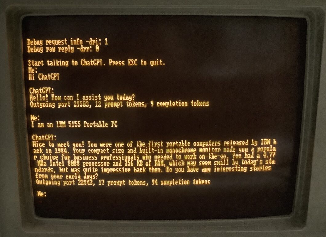 Monitor de computador IBM 5155 de fundo âmbar exibindo uma conversa de terminal com o ChatGPT, em texto em caixa-alta e sem acentuação, rodando no DOS