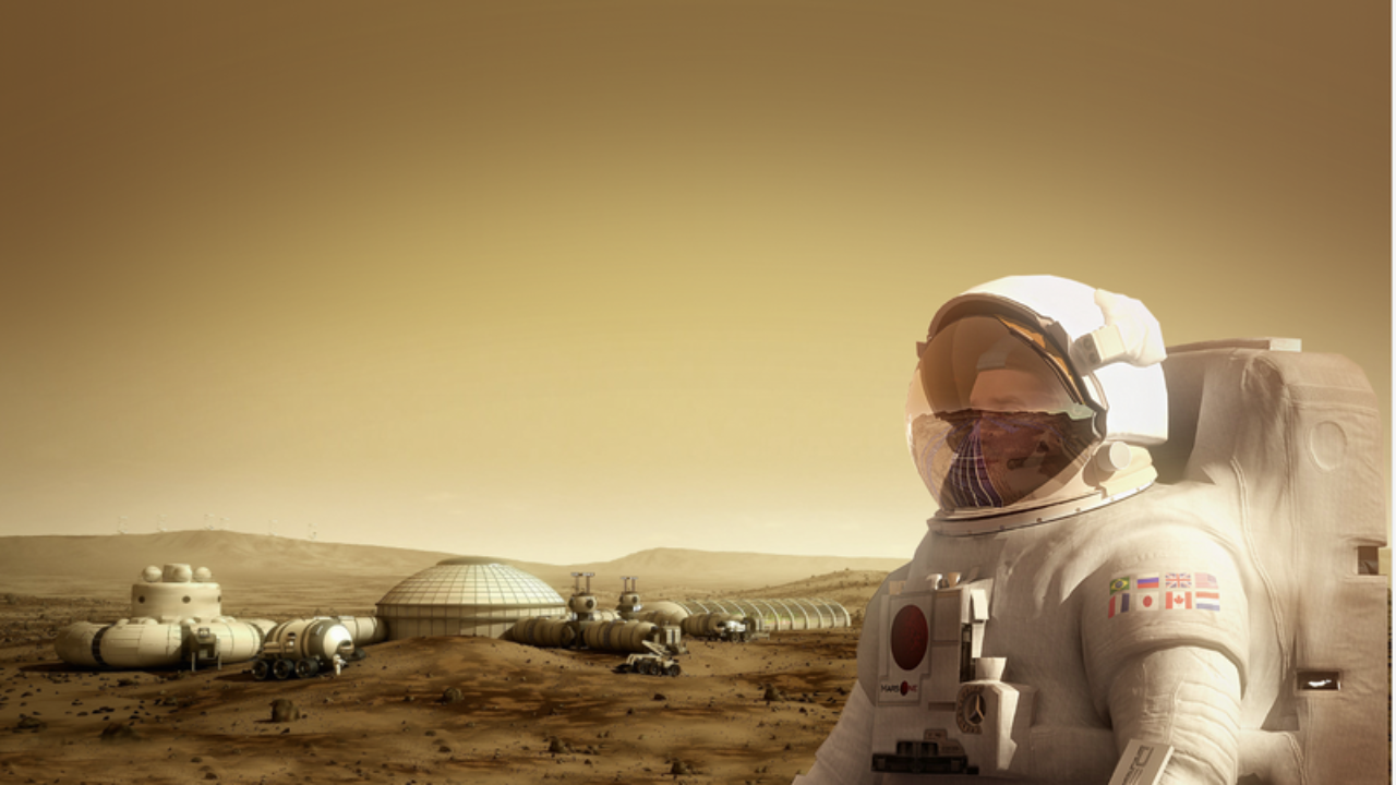 Astronauta com traje espacial, com bandeiras de países no ombro, observa uma colônia de habitats domos e veículos sobre a superfície avermelhada de Marte